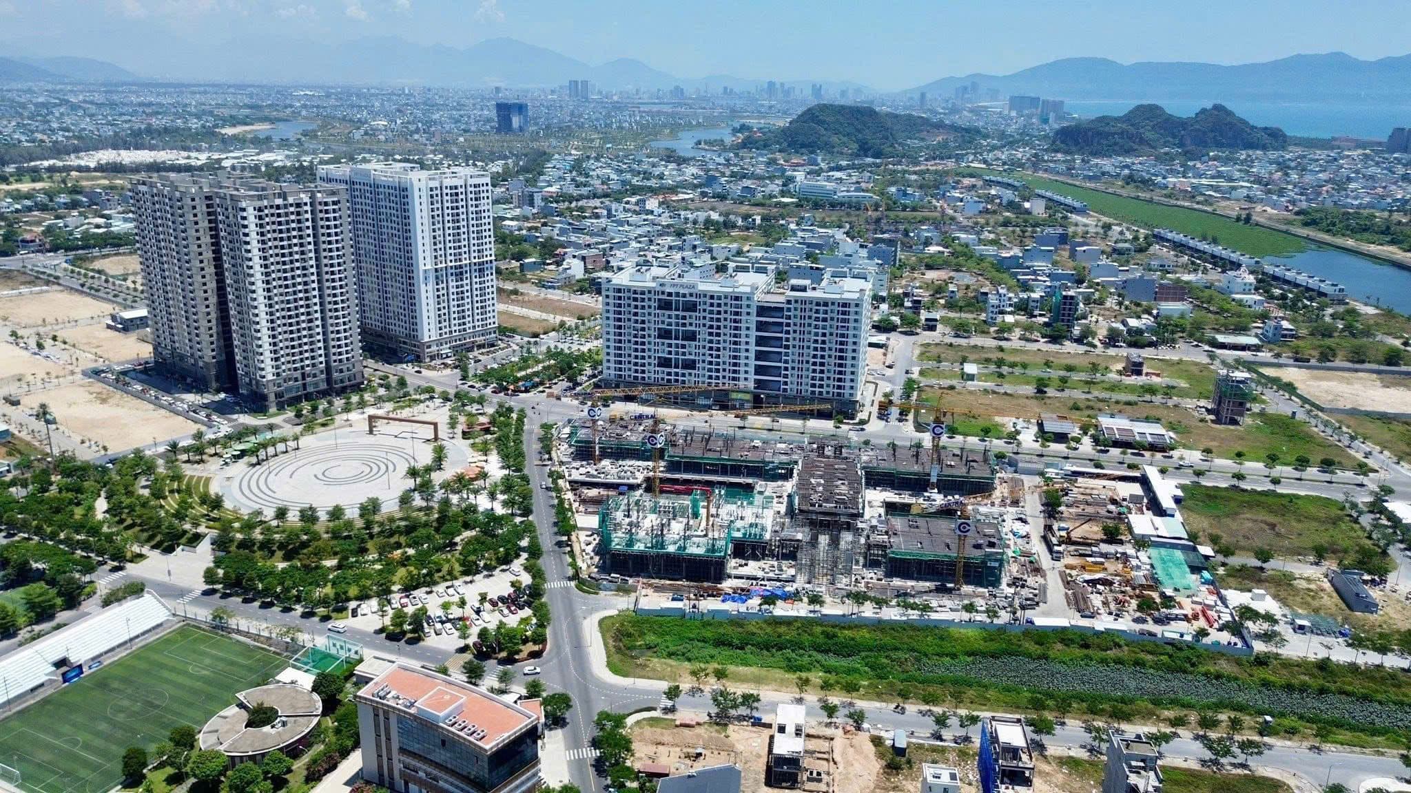 Aerial view of high-rise apartments and construction in a growing city surrounded by mountains