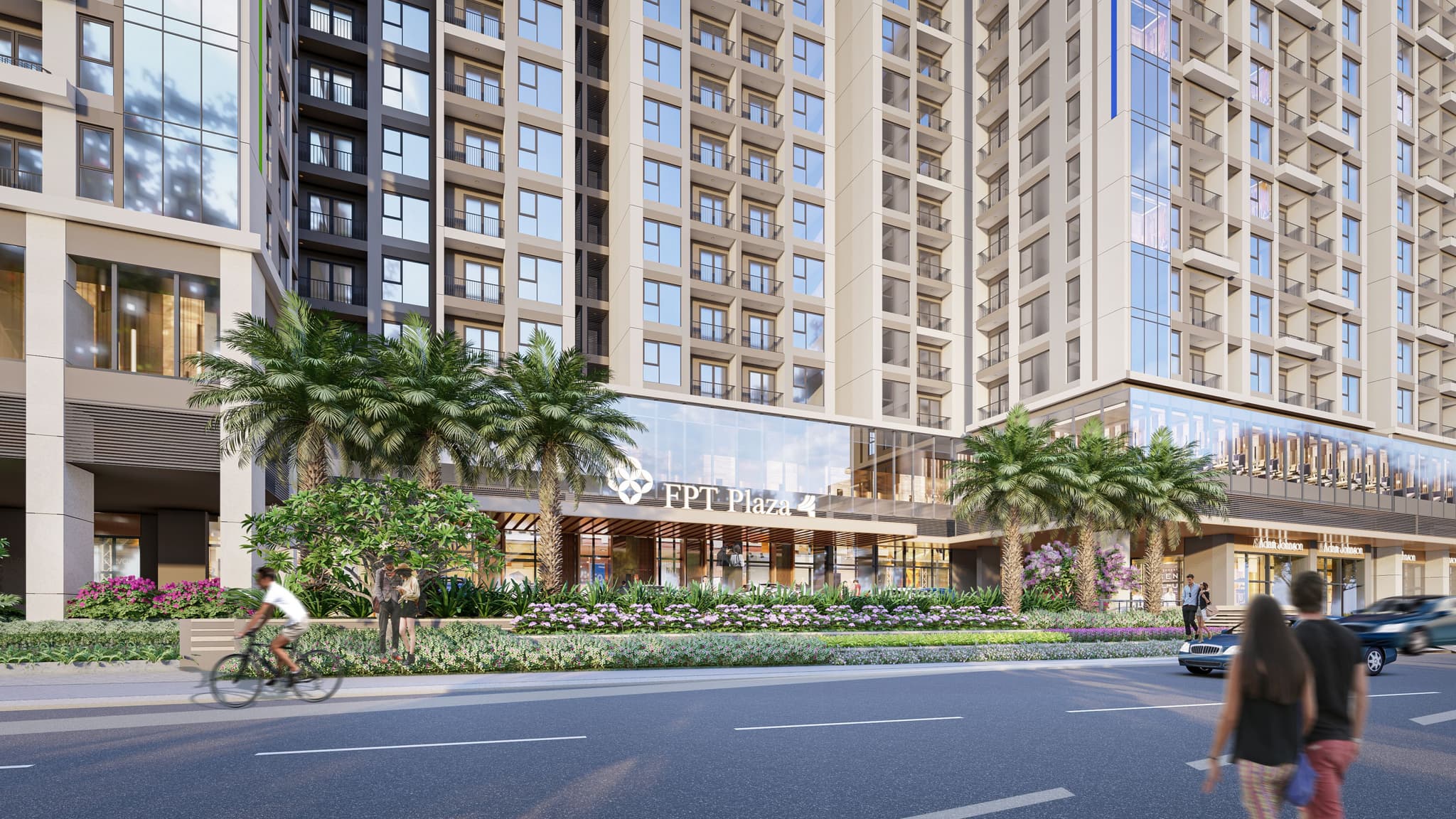 Modern residential building with large glass windows, surrounded by palm trees and landscaped gardens, located on a bustling street.