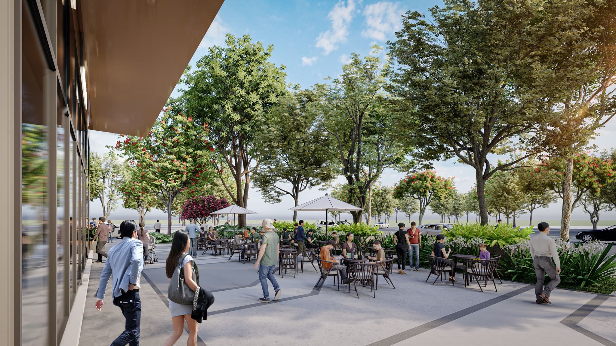Vibrant outdoor dining area with trees, tables, and umbrellas, bustling with people enjoying the atmosphere.